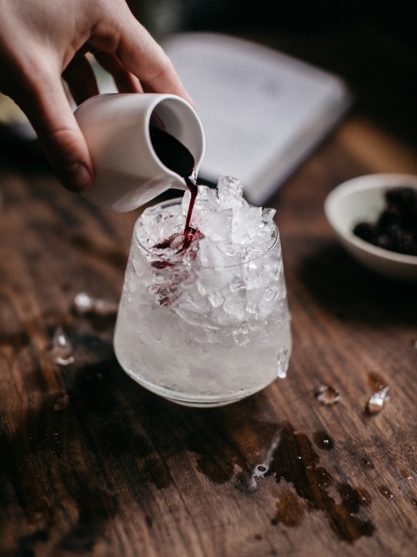 Pouring the creme de mure on a Bramble